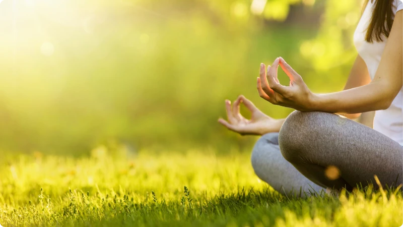 Mulher praticando meditação mindfulness ao ar livre. Descubra como a meditação mindfulness pode transformar a sua vida.