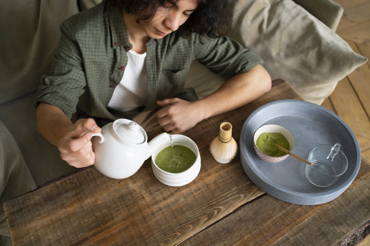 Homem desfrutando de uma xícara de chá verde.