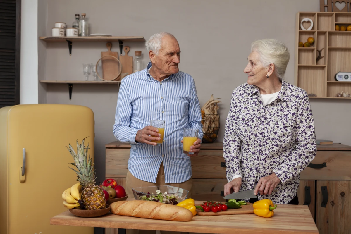 Alimentação para Idosos: Cuidados e Recomendações. Um casal de idosos na cozinha preparando uma refeição.