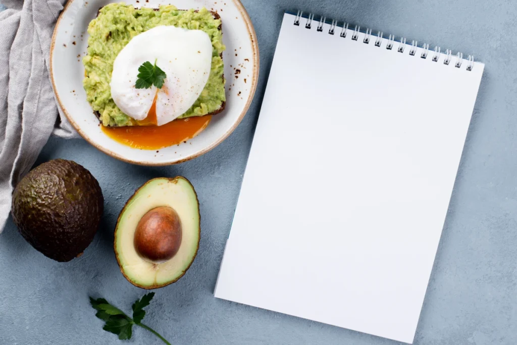 Dieta Cetogênica: o que é, como funciona e o que comer. Vista superior de uma mesa com torradas de abacate no prato e ovo escalfado na parte superior.