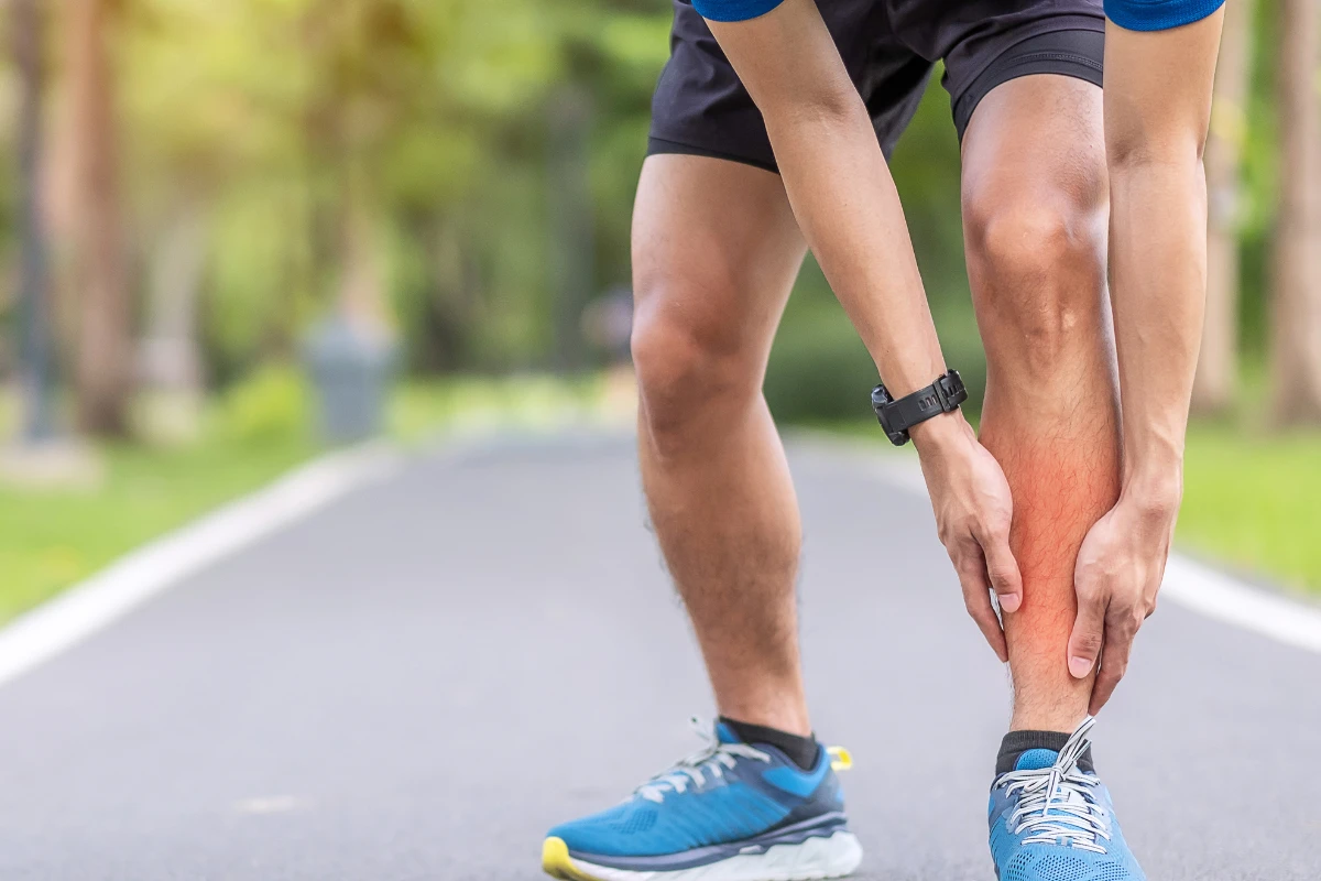 Canelite: O que é, Sintomas, Causas e Tratamentos. Homem adulto, jovem, corredor com fortes dores nas canelas.