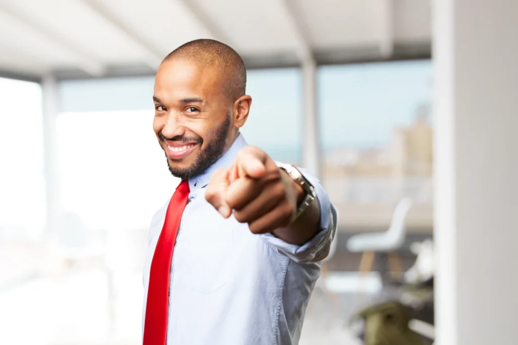 Motivação: o que é, tipos e como desenvolver na vida. Rapaz jovem feliz motivado apontado o dedo indicador.