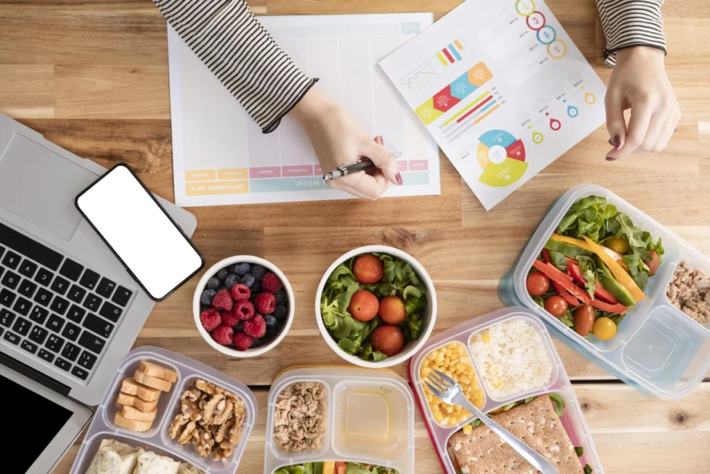 Diário Alimentar: O Que é, Como Funciona e Como Fazer. Gráficos de vista superior e alimentos orgânicos em caixas de almoço.