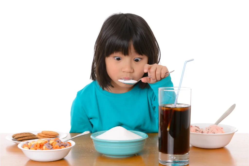 Refrigerante Faz Mal? Descubra a Verdade e Proteja Sua Saúde. Criança com excesso de açúcar comendo muita comida doce.