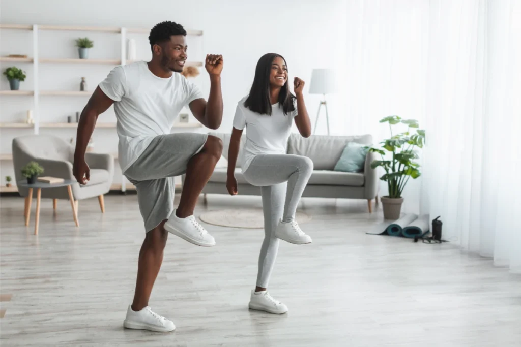 Treino Tabata: 4 Minutos Para Transformar Seu Corpo. Um jovem casal fazendo exercícios de joelho alto.