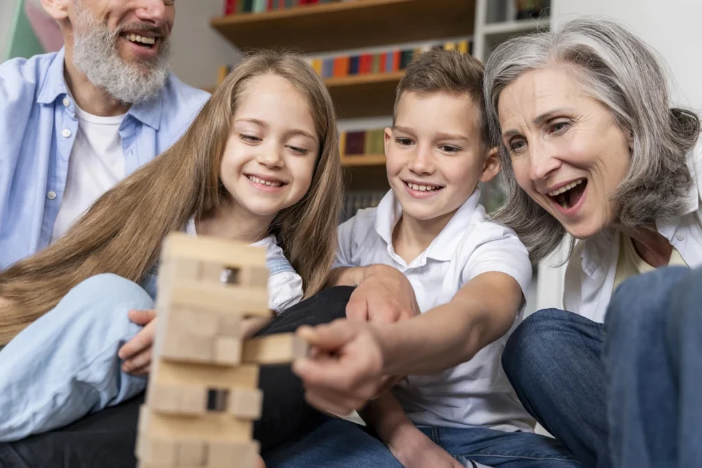 Atividades para idosos: 50+ opções práticas e seguras. Avôs brincando com os netos em casa.