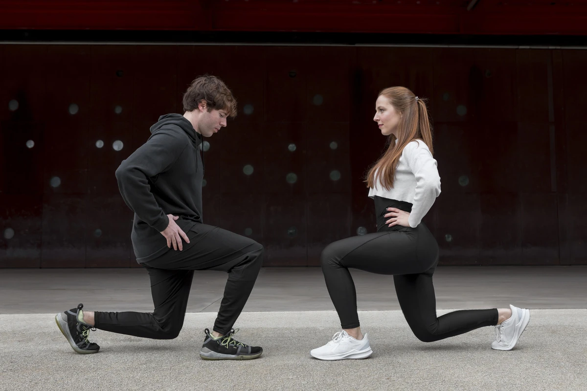 Pessoas em roupas esportivas praticando Agachamento Sumô em exercício ao ar livre durante treino funcional