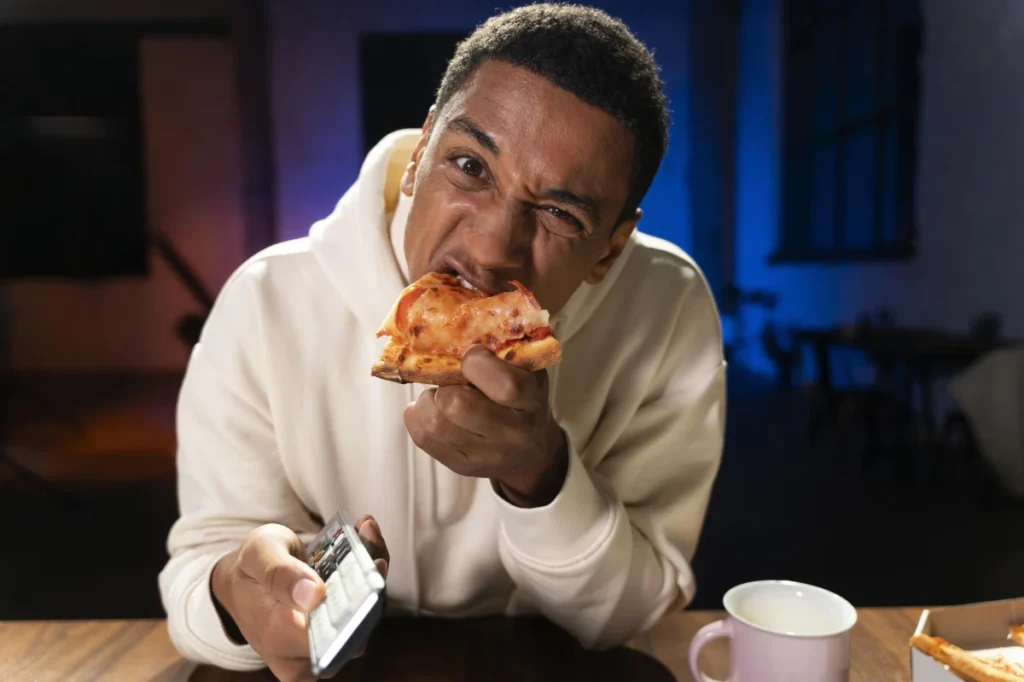 Comer Devagar: Benefícios e Como Fazer Corretamente. Homem comendo pizza desesperadamente.