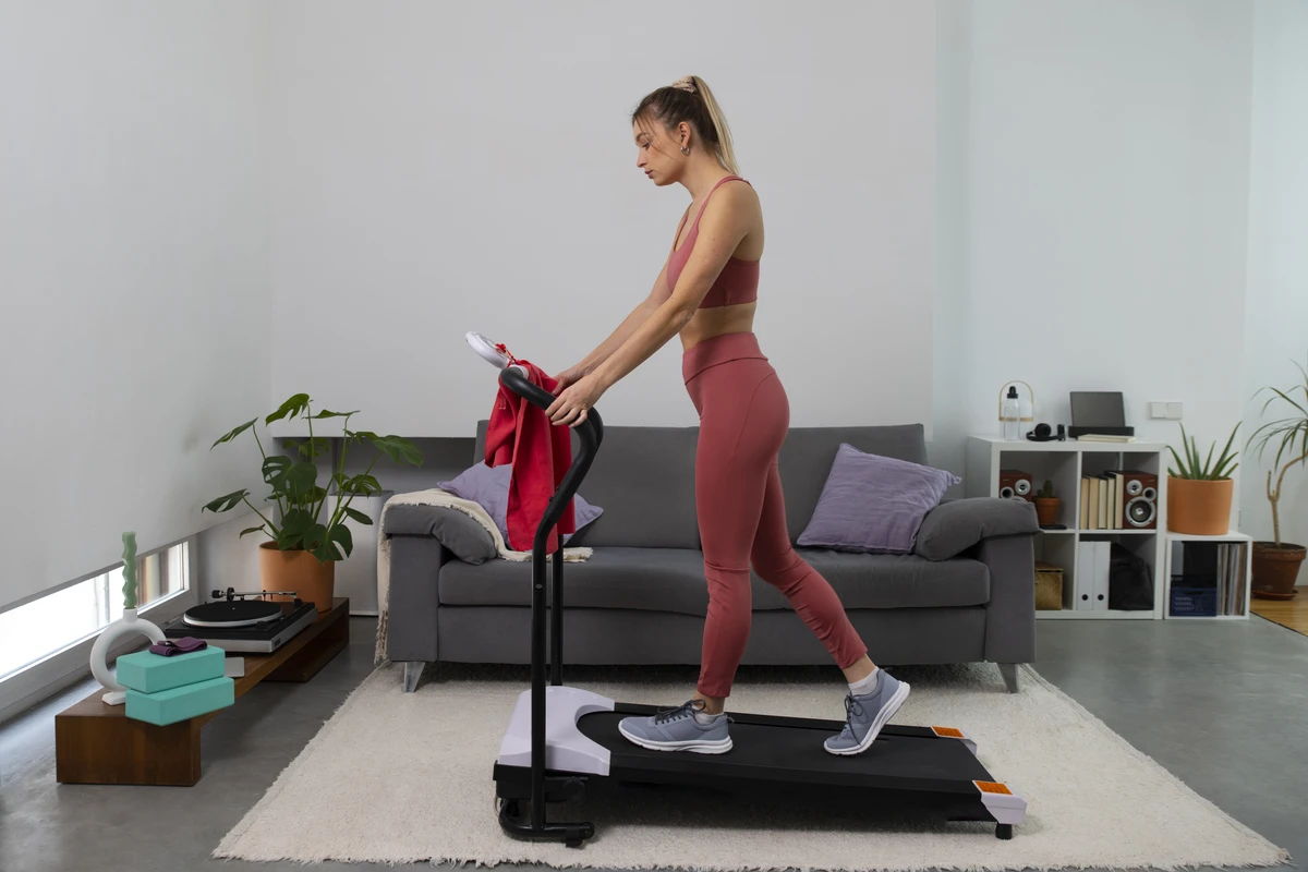 Mulher correr na esteira em academia, vista de corpo inteiro durante exercício cardiovascular